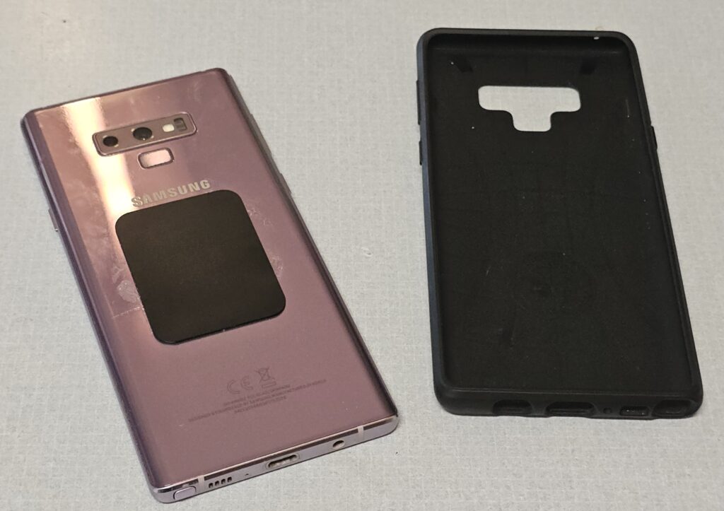 A Samsung phone with a ferrous (sticks to magnets) plate stuck to the back. Next to it, a simple silicone slip-case.