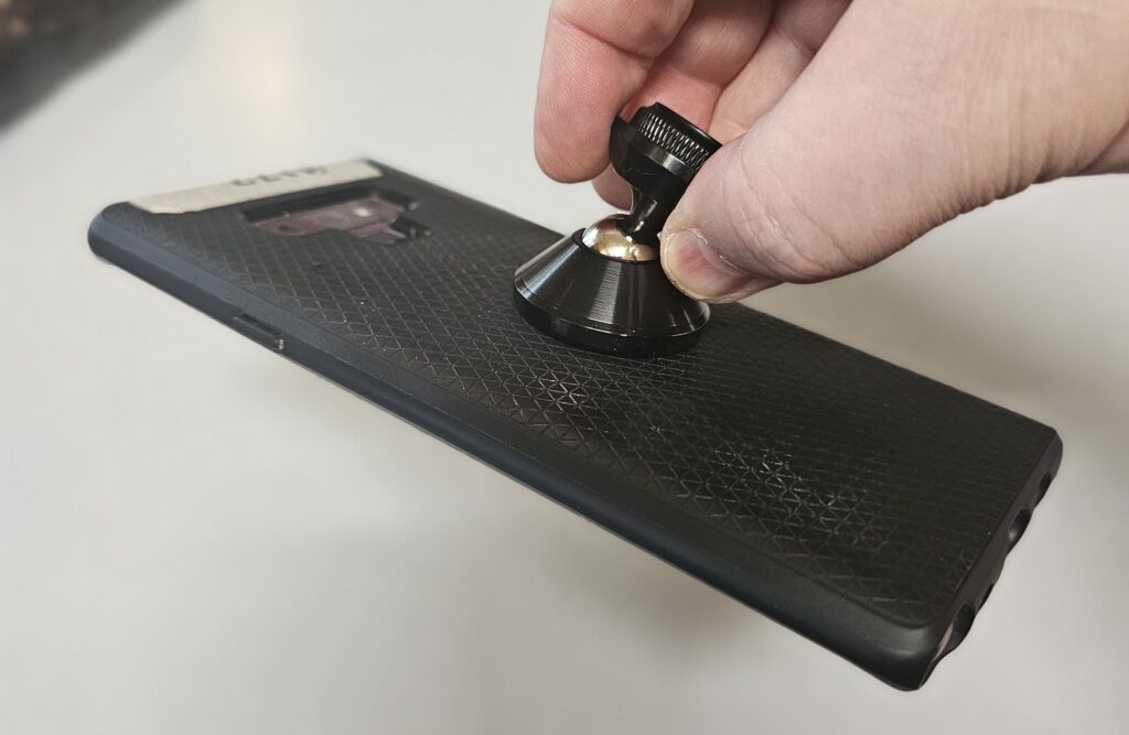 The phone is inside the slip case. The Coolpow magnet has no trouble holding it securely, grabbing that ferrous plate right through the case.