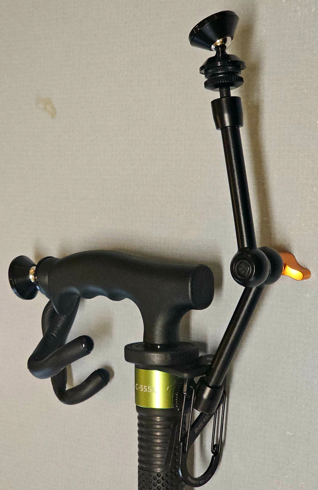 A Manbily C-555L Monopod with the Magic Arm assembly for the phone, a spring-clip for attaching car keys, a padded twist-tie for hanging it over a chair, and a magnet on the handle for docking it against a steel door frame.